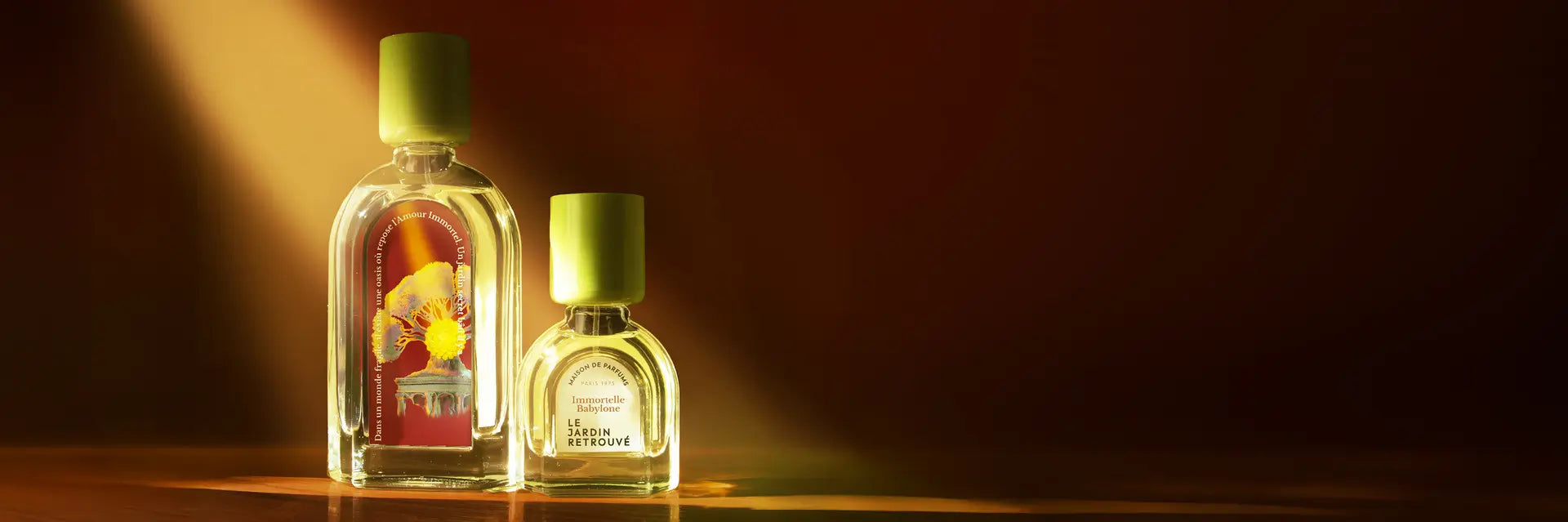 Immortelle Babylone 15 et 50 ml sur une table avec un rayon de soleil, le fond est marron