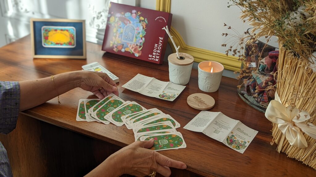 Cartes de l'Oracle du Jardin retrouvé disposer par Clara Feder entouré de produit , sur un mobilier